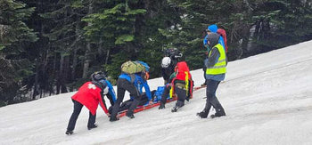 rescue team with patient on snowy slope