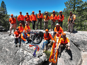 rescue team in orange shirts on rock in forest