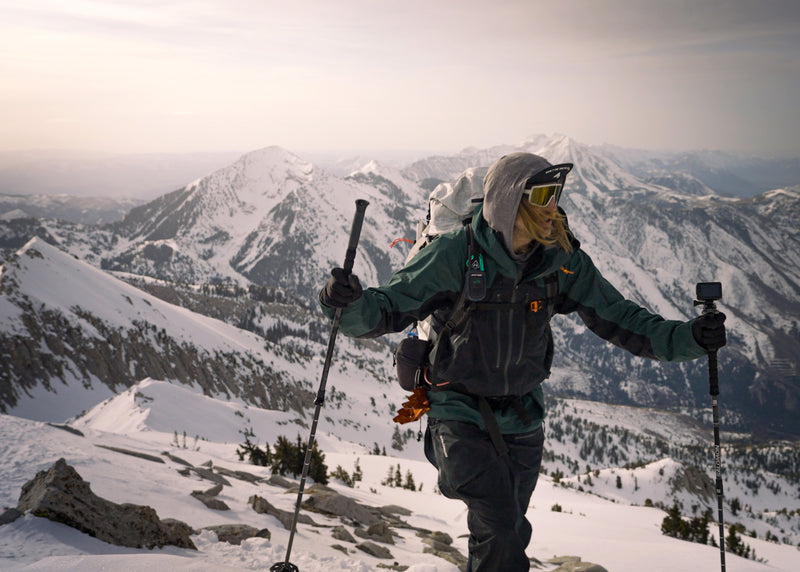 Person hiking on a snowy mountain with ski poles and backpack
