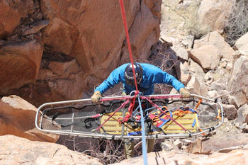 SAR team member lowering litter