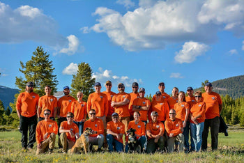 People in orange shirts posing for group photo