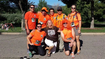 rescue team in orange shirts posing in parking lot