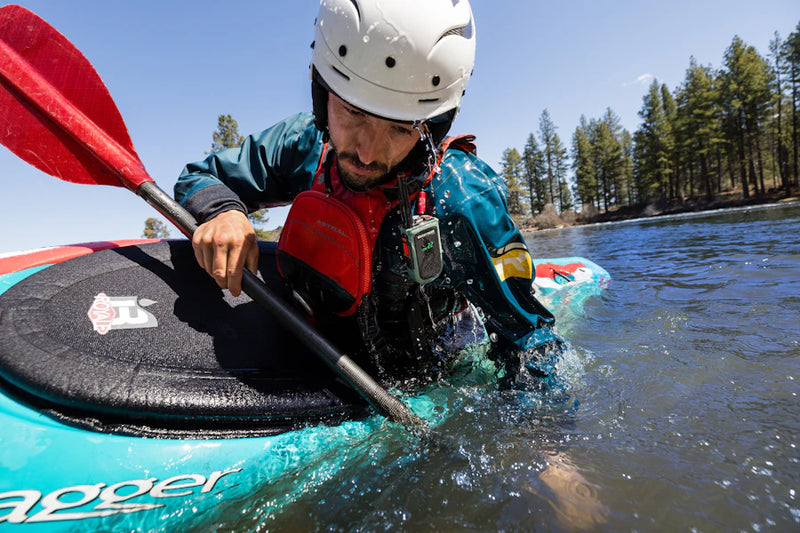 Person kayaking on a lake with trees in the background