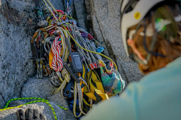 Close-up of climbing equipment on a rock with a climber in the background