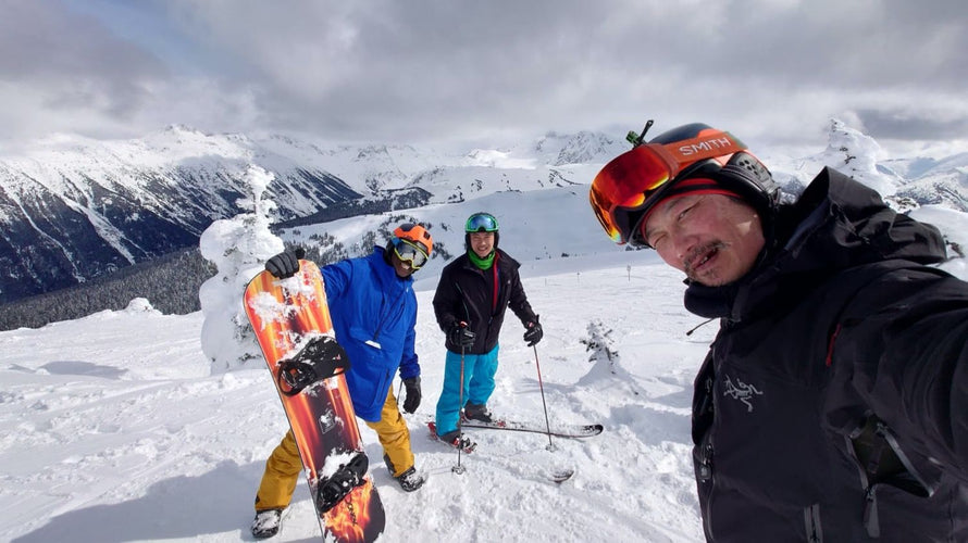 Three people on a snowy mountain with ski equipment