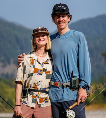 Two flyfisherpeople posing for photo in mountains