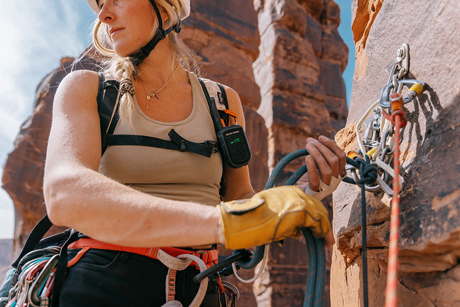 Person climbing a rock wall with climbing gear