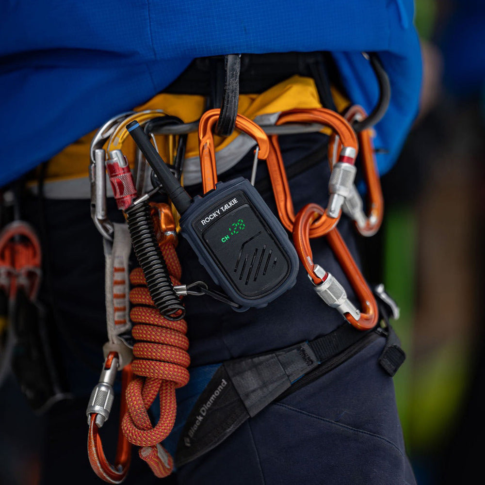 Person wearing climbing gear with orange ropes and carabiners on a blurred background