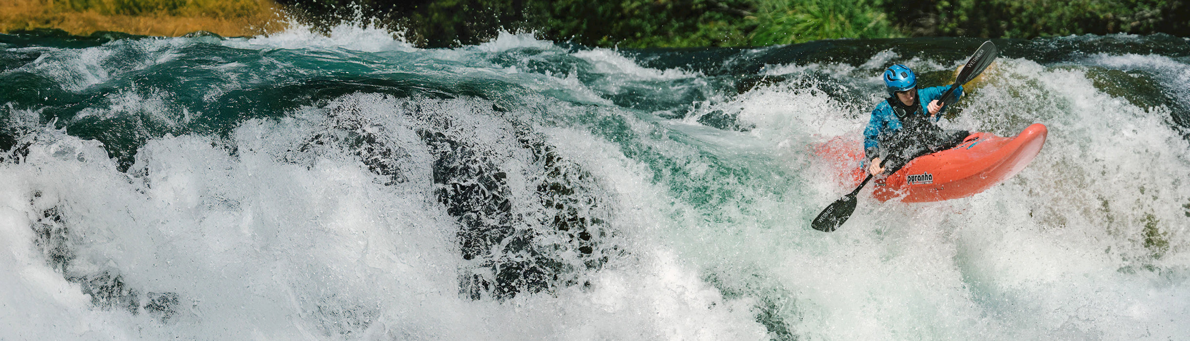 Person kayaking in turbulent water with greenery in the background