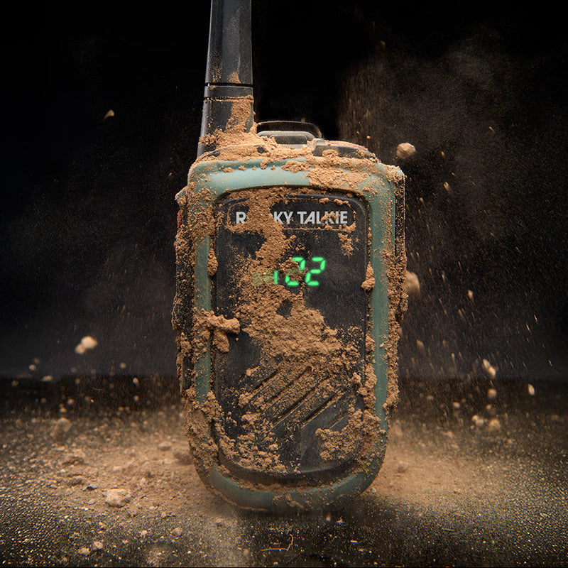 Muddy walkie-talkie with digital display on a dark background