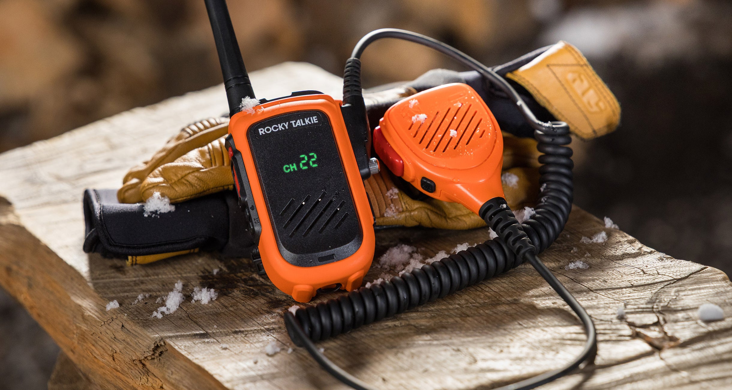 Hi-Vis Expedition Radio with Hand Mic attached sitting on a block of wood