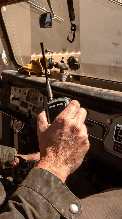 Hand operating a radio in the driver's seat of a vehicle