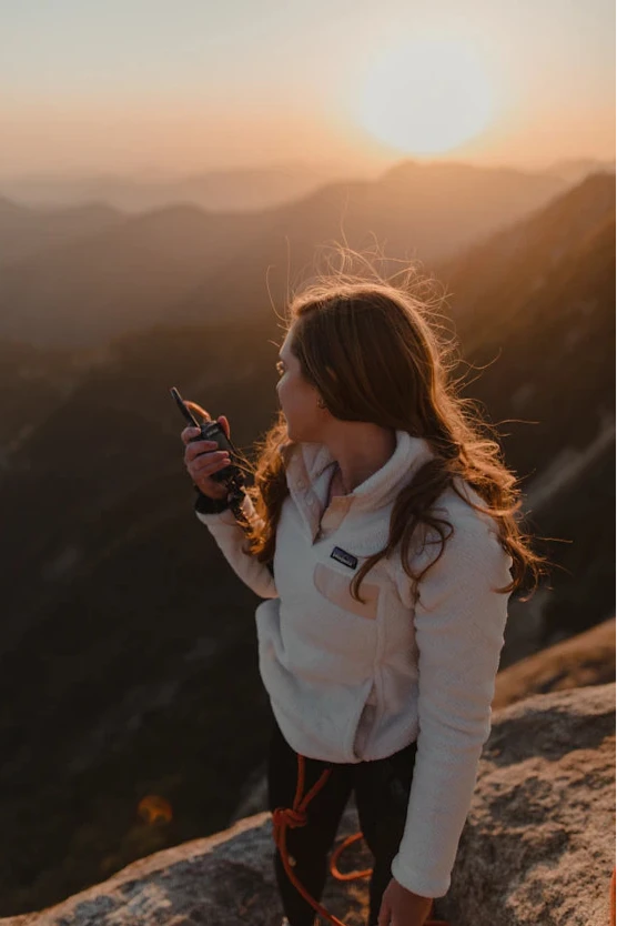 Person taking a photo of a sunset over mountains