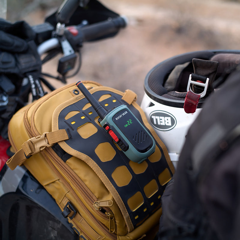 Brown bag with Expedition Radio on a motorcycle, helmet in the background