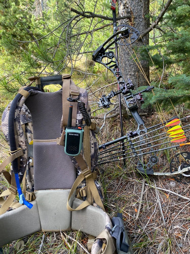 Camouflage hunting chair with bow and quiver in a forest setting