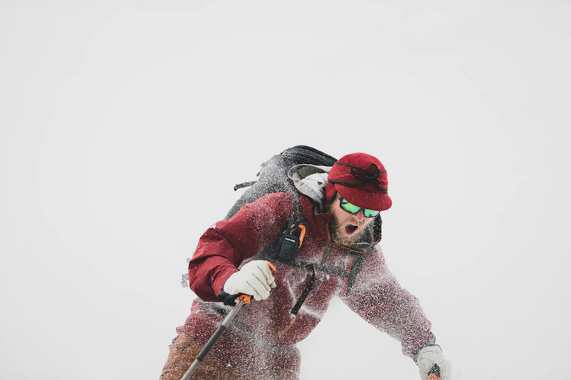 Person skiing in a snowy landscape with a backpack