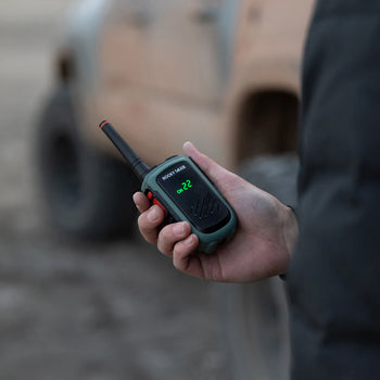 Expedition radio in hand with truck in background