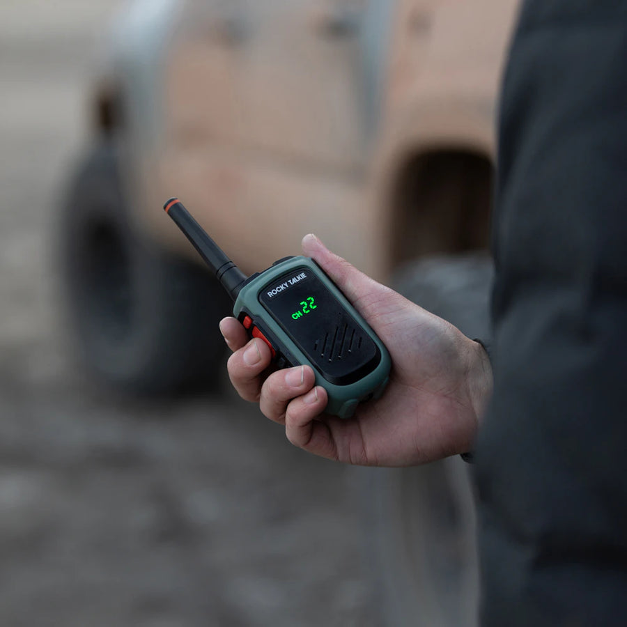 Expedition radio in hand with truck in background