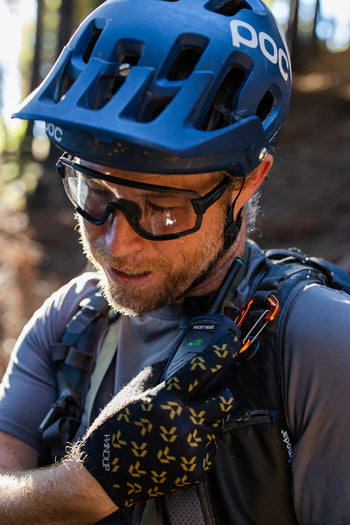 Person wearing a blue bike helmet using a radio outdoors