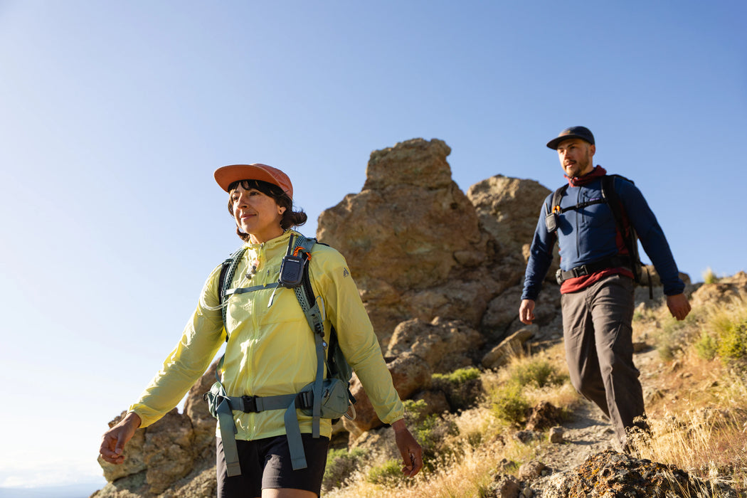 Two hikers on a rocky trail with clear blue sky