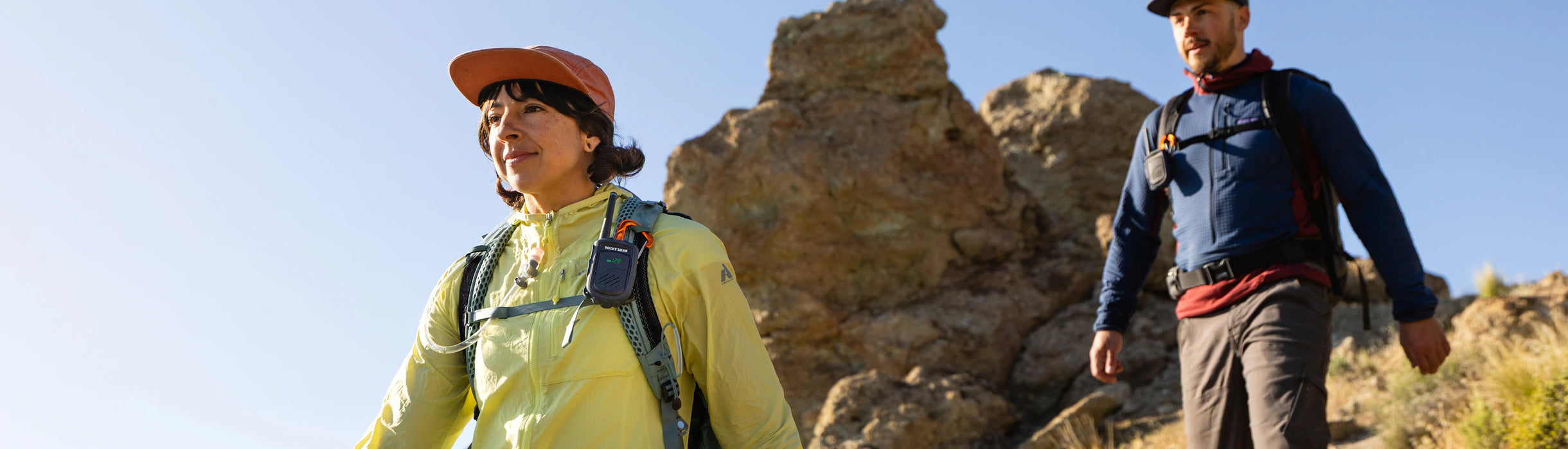 Two hikers on a rocky trail with clear blue sky