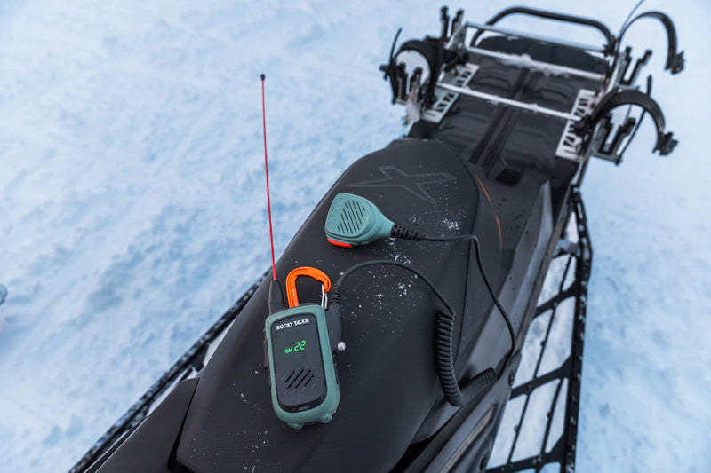 Snowmobile with a radio and hand mic on a snowy background