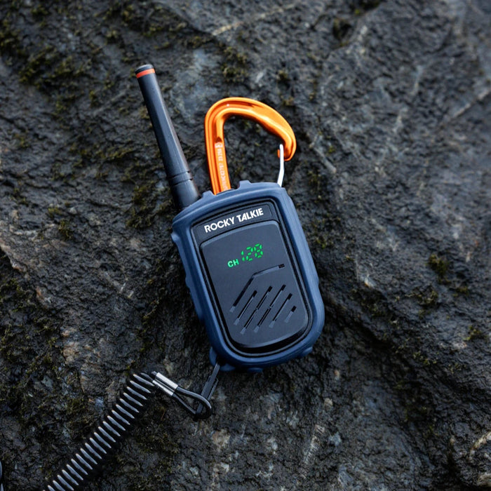 Rocky Talkie walkie talkie with orange carabiner on a rocky surface