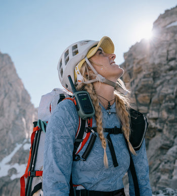 Woman on alpine climb with helmet and radio